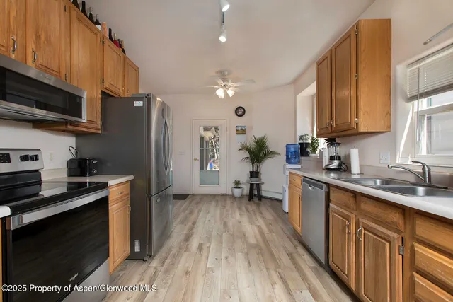 a kitchen with stainless steel appliances a stove a sink dishwasher a refrigerator and a stove top oven