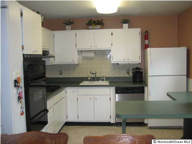 70 Darien Road Howell, NJ 07731 - Photo 3 of 26 a kitchen with cabinets and a refrigerator