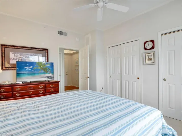 a bedroom with a bed and a flat tv screen on dresser