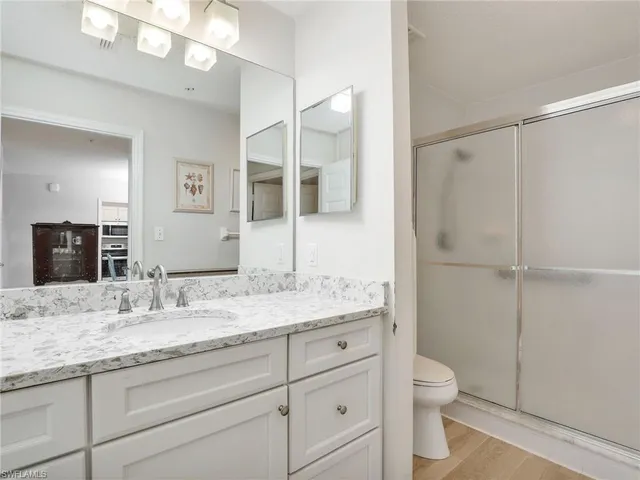 a bathroom with a granite countertop sink toilet and shower