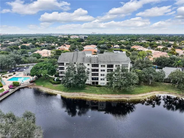 an aerial view of a house with a yard lake view and mountain view in back
