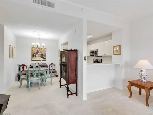 a living room with furniture a refrigerator and dining table