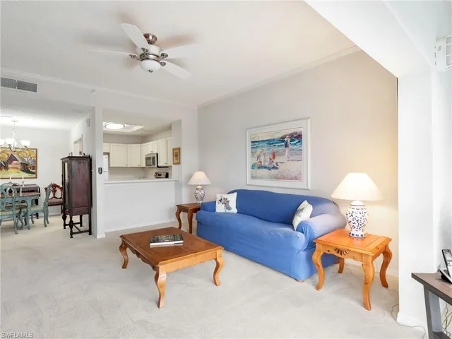 a living room with furniture kitchen view and a chandelier