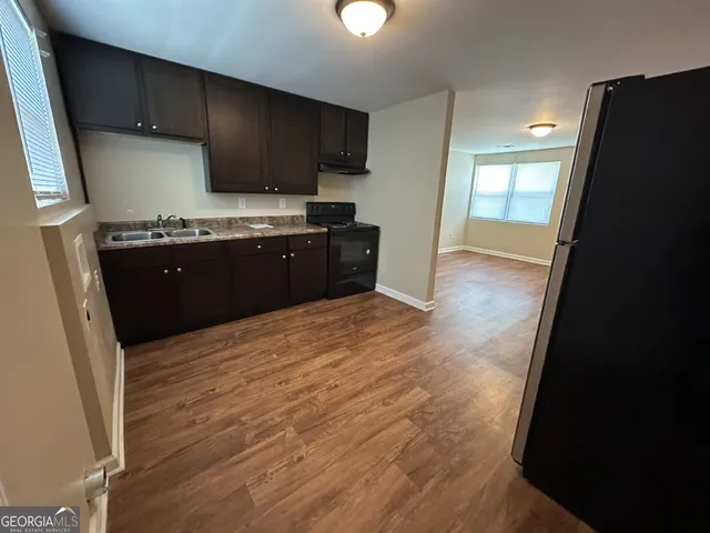 a kitchen with granite countertop a refrigerator stove and sink
