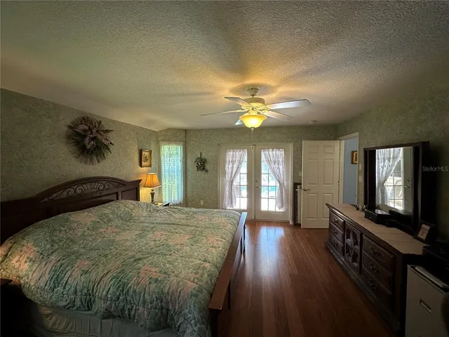 a bedroom with a bed and a flat tv screen on dresser