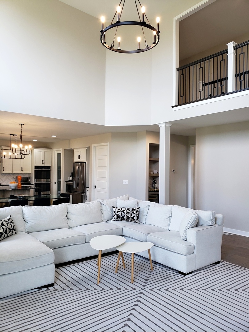 4327 Carpenter Road Naperville, IL 60564 - Photo 16 of 42 a living room with furniture a rug and a chandelier