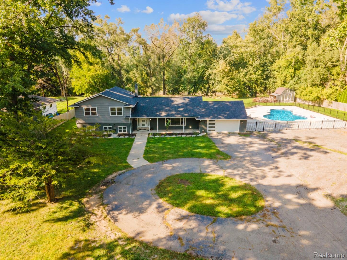 15879 Millar Road Clinton Township, MI 48036 - Photo 50 of 65 Contemporary residence with a dark gray exterior, attached garage, and a large inground pool