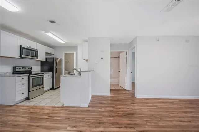a kitchen with a refrigerator and a stove top oven