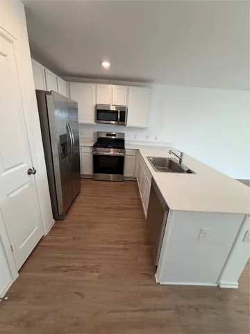 a kitchen with a sink a refrigerator a microwave and cabinets