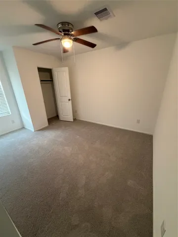an empty room with a ceiling fan and a window