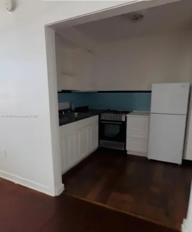 a kitchen with granite countertop a stove and a refrigerator