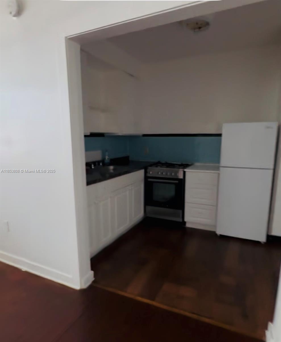 1611 Pennsylvania Avenue, Unit 6 Miami Beach, FL 33139 - Photo 1 of 4 a kitchen with granite countertop a stove and a refrigerator
