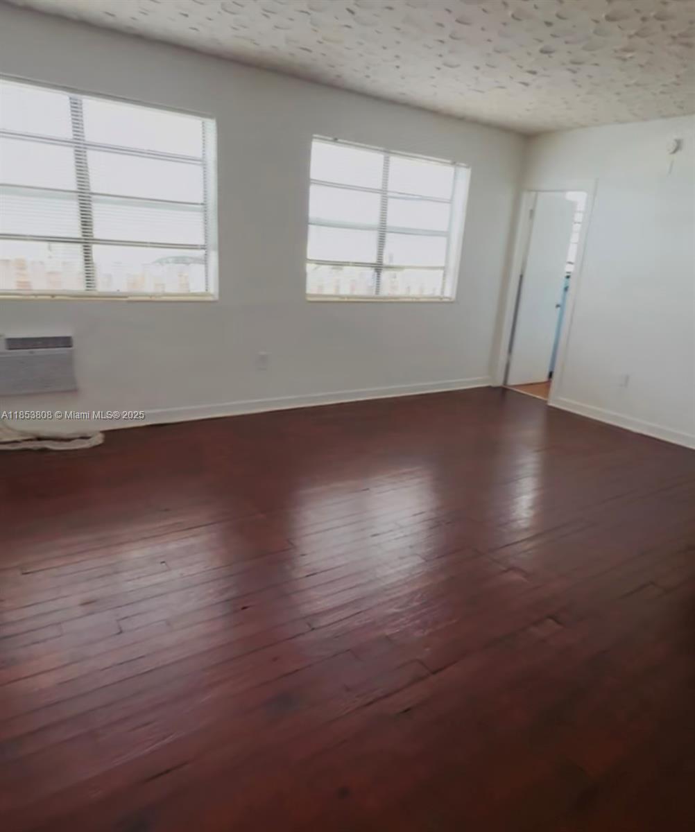 1611 Pennsylvania Avenue, Unit 6 Miami Beach, FL 33139 - Photo 4 of 4 an empty room with wooden floor and windows
