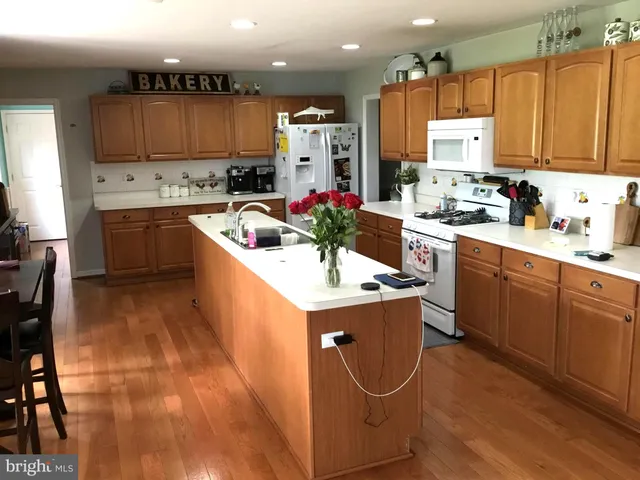 a kitchen with stainless steel appliances a sink a stove a refrigerator cabinets and a center island