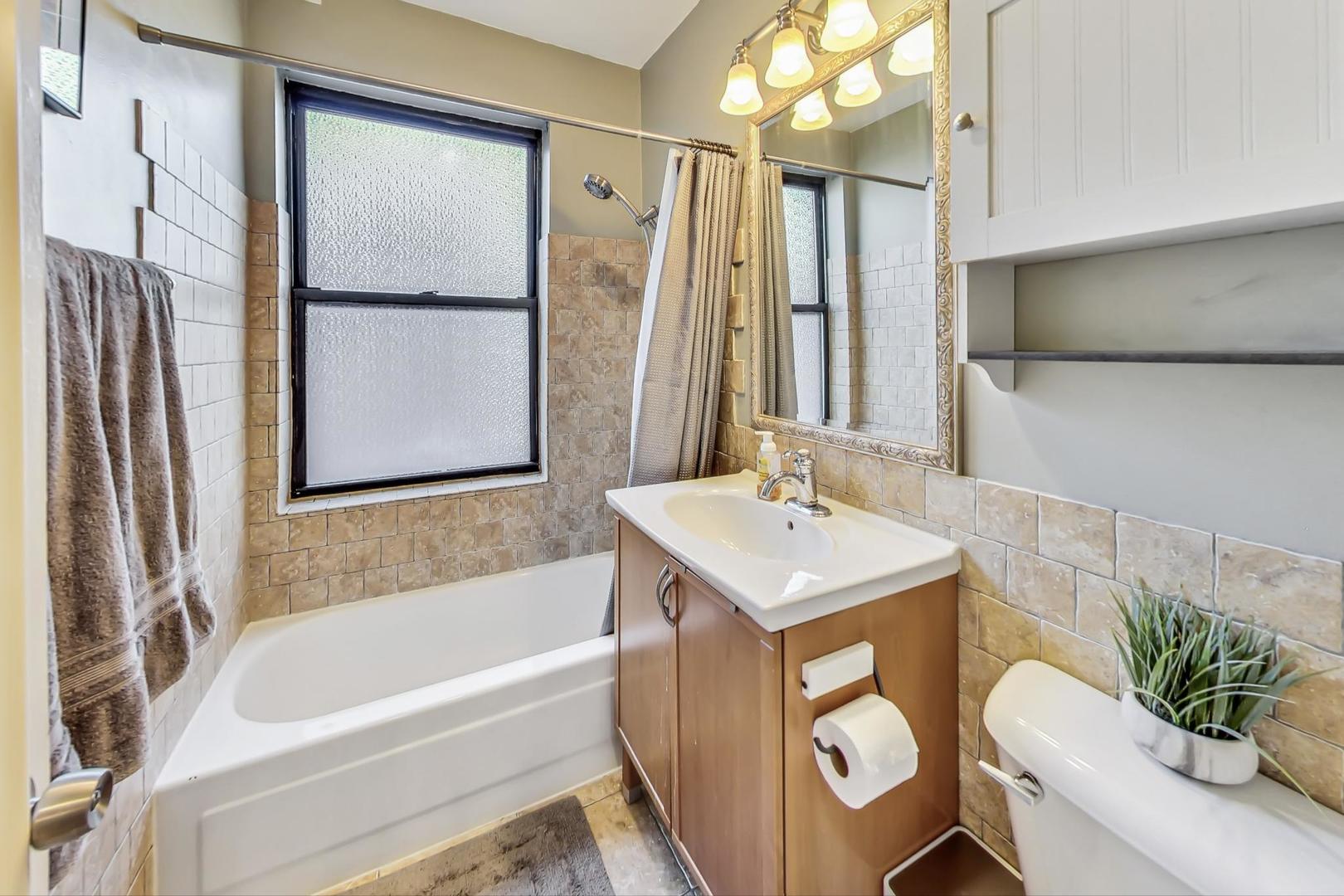 725 West Sheridan Road, Unit 601 Chicago, IL 60613 - Photo 13 of 23 a bathroom with a sink a bathtub and a mirror