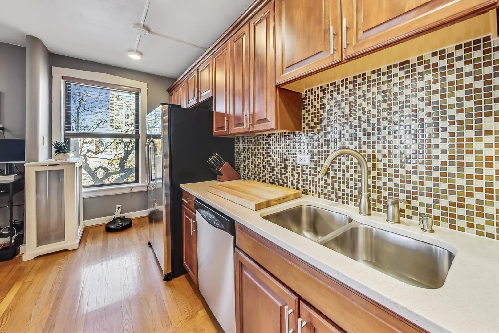 725 West Sheridan Road, Unit 601 Chicago, IL 60613 - Photo 6 of 23 a kitchen with a sink cabinets and wooden floor
