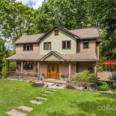 a front view of a house with a yard patio and green space