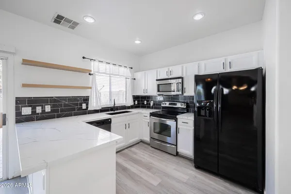 a kitchen with granite countertop a refrigerator stove and sink