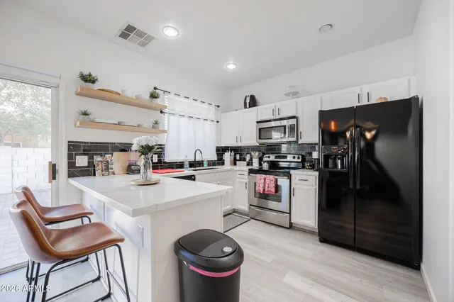 a kitchen with a sink stainless steel appliances and white cabinets