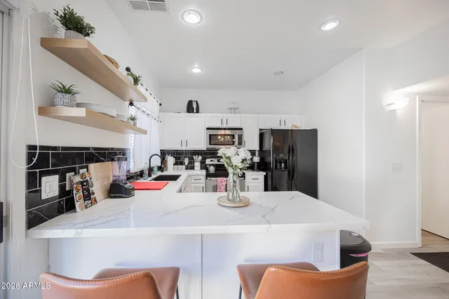 a kitchen with stainless steel appliances kitchen island granite countertop a refrigerator and microwave