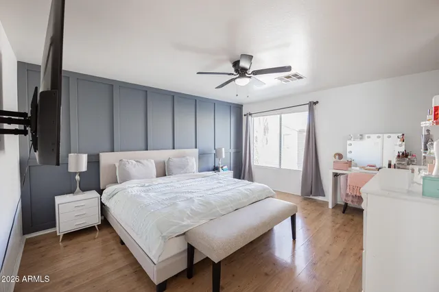 a bedroom with a bed a ceiling fan and a dresser
