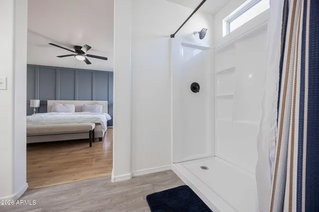 a bedroom with a bed and a ceiling fan