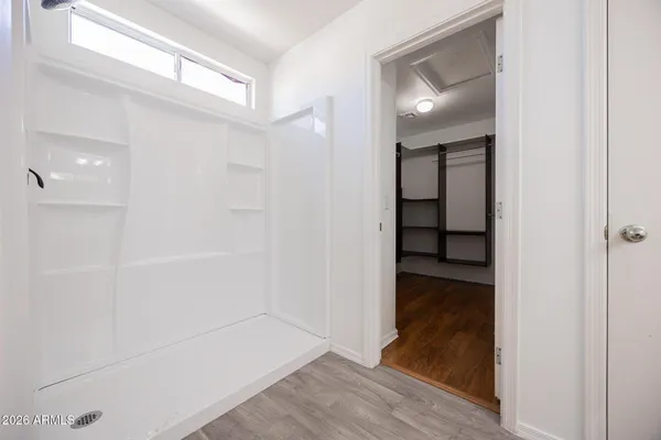 a view of a hallway with wooden floor and closet