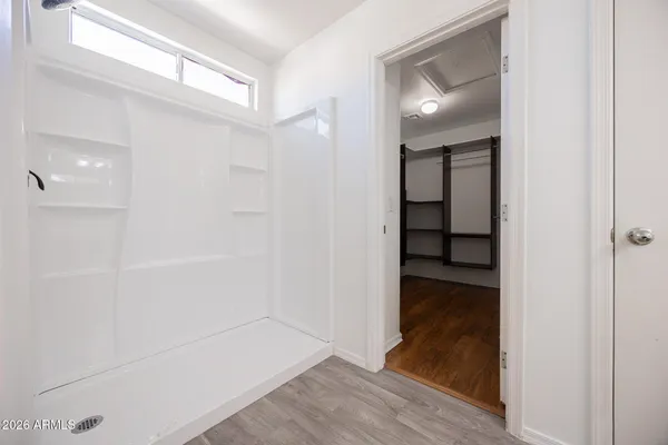 a view of a hallway with wooden floor and closet
