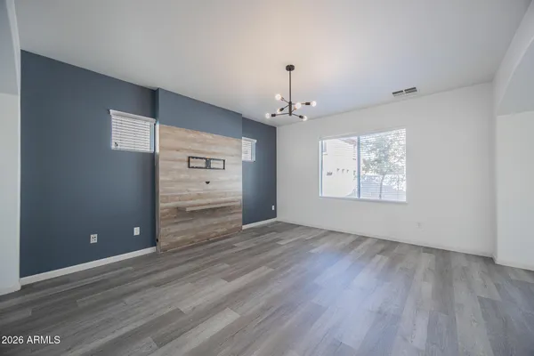 a view of a hallway with wooden floor and chandelier