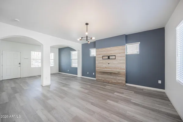 a view of an empty room with window and wooden floor
