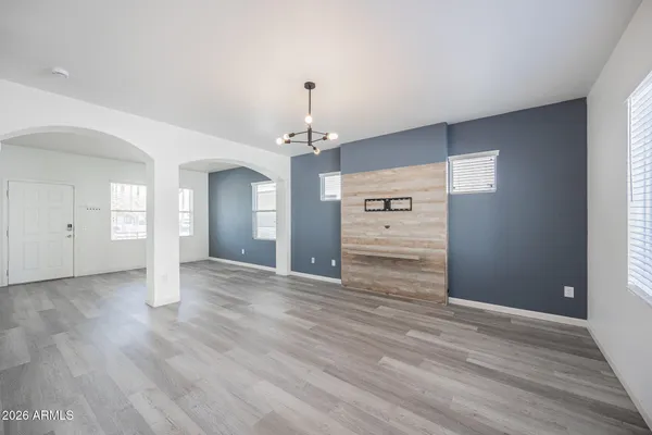 a view of an empty room with window and wooden floor