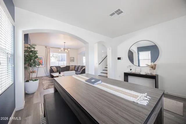 a large bedroom with a bed a mirror and a potted plant