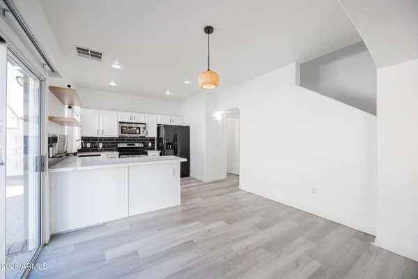 a kitchen view with stainless steel appliances a refrigerator and a stove top oven