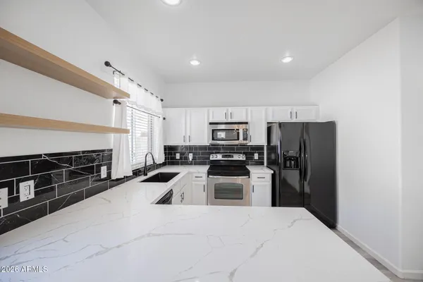 a kitchen with stainless steel appliances a refrigerator a stove a sink a washer and dishwasher