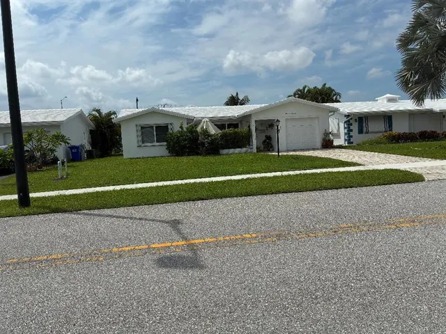 a front view of a house with a garden and yard