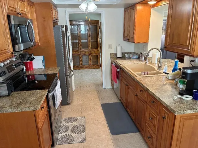 a kitchen with stainless steel appliances granite countertop a sink stove and refrigerator