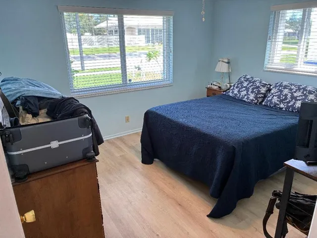 a bedroom with a bed and windows