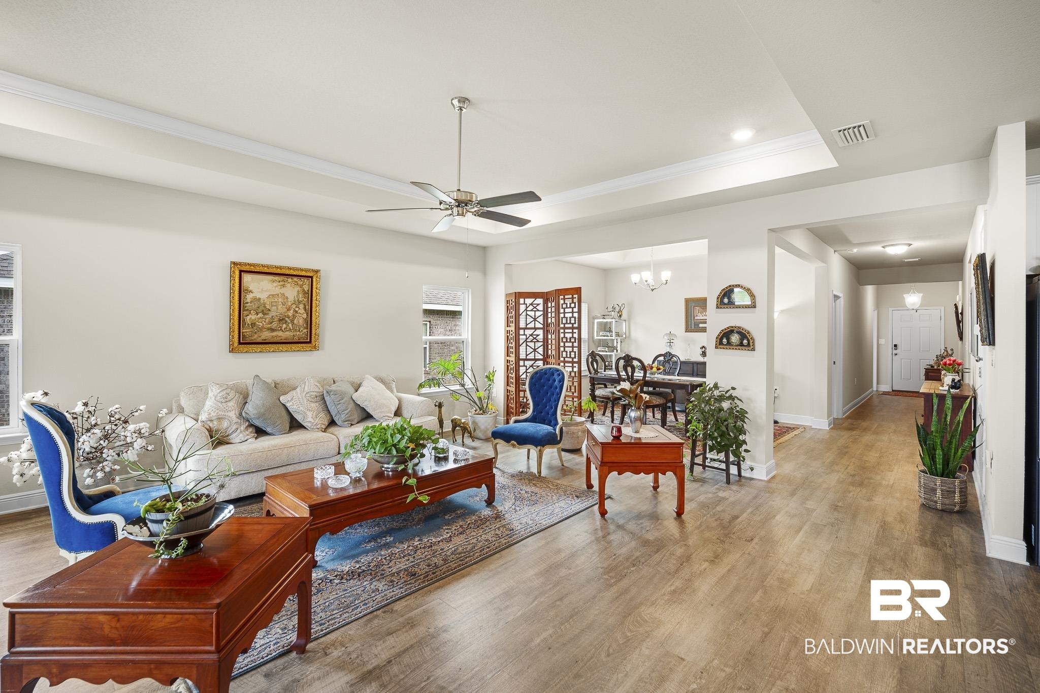 24765 Spectacular Bid Loop Daphne, AL 36526 - Photo 14 of 45 Living room with ornamental molding, a tray ceiling, ceiling fan with notable chandelier, and light hardwood / wood-style flooring