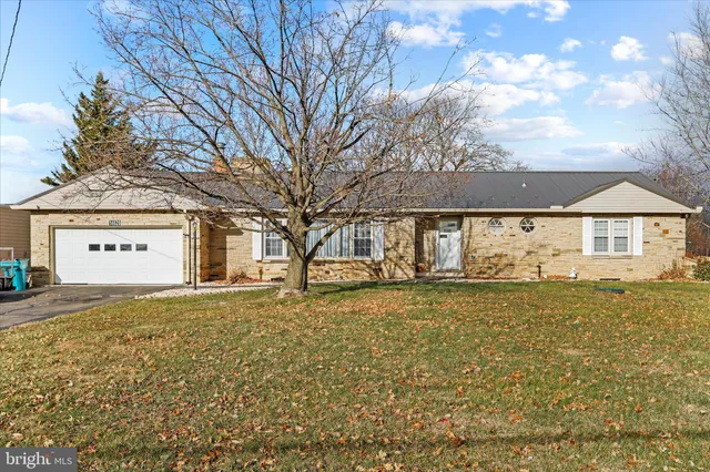 a large tree in front of a white house