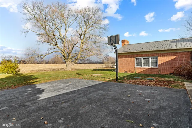 a front view of house with yard and trees in the background