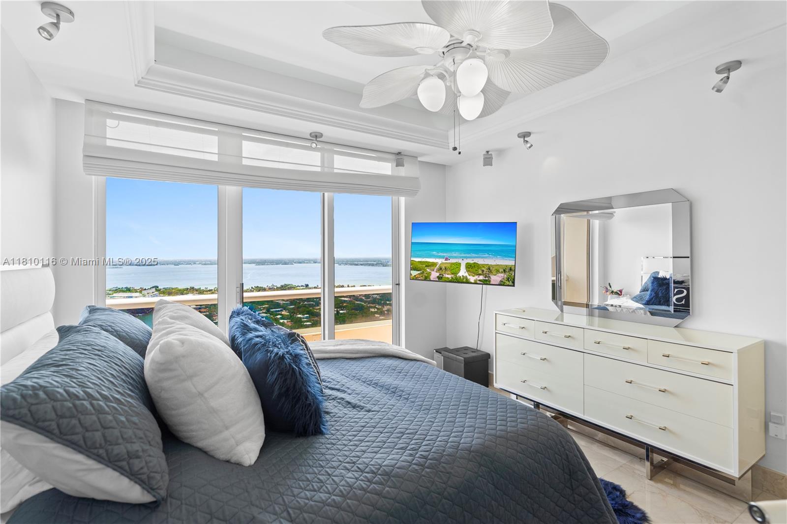 4775 Collins Avenue, Unit PH4107 Miami Beach, FL 33140 - Photo 28 of 62 a spacious bedroom with a large bed and a chandelier