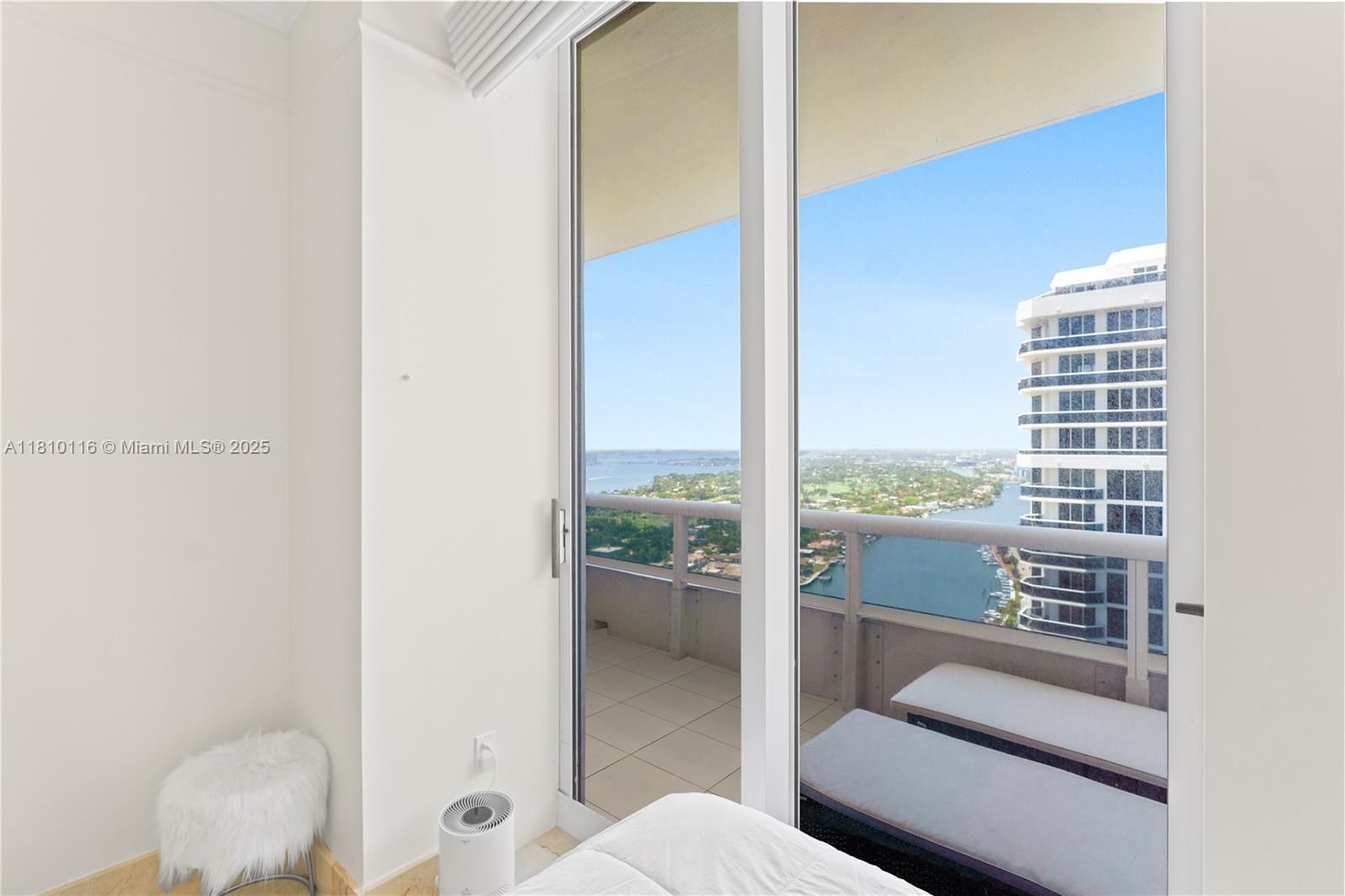 4775 Collins Avenue, Unit PH4107 Miami Beach, FL 33140 - Photo 37 of 62 a living room with furniture and a floor to ceiling window