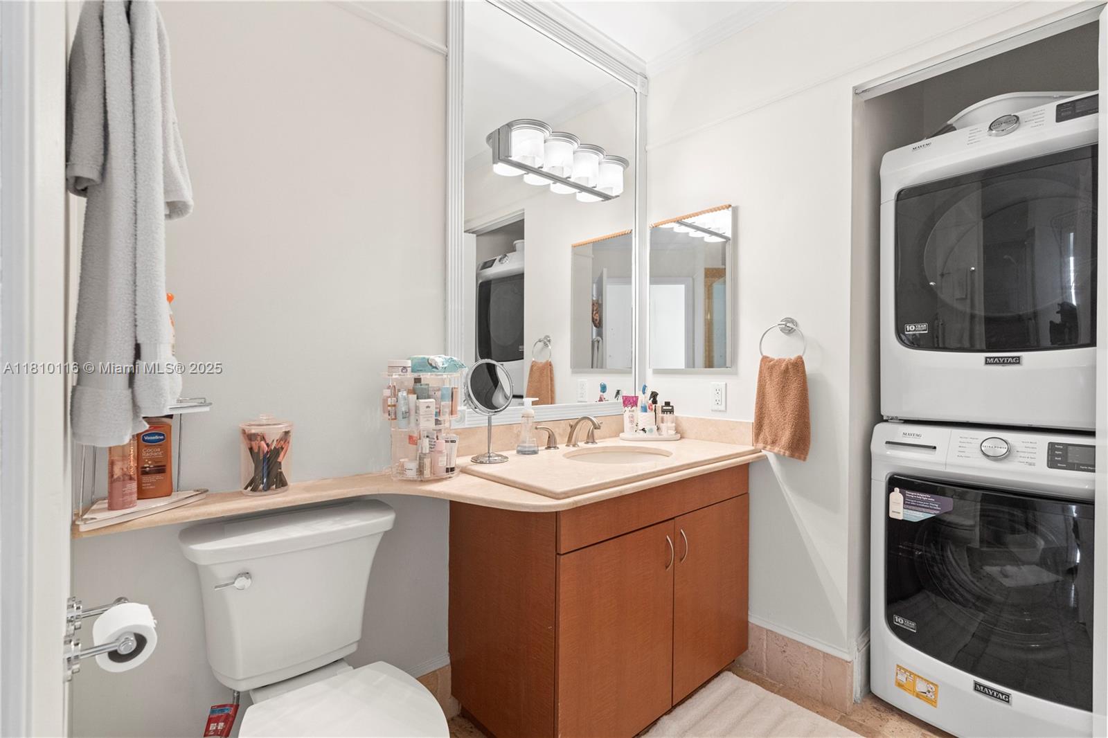 4775 Collins Avenue, Unit PH4107 Miami Beach, FL 33140 - Photo 41 of 62 a bathroom with a toilet sink and mirror