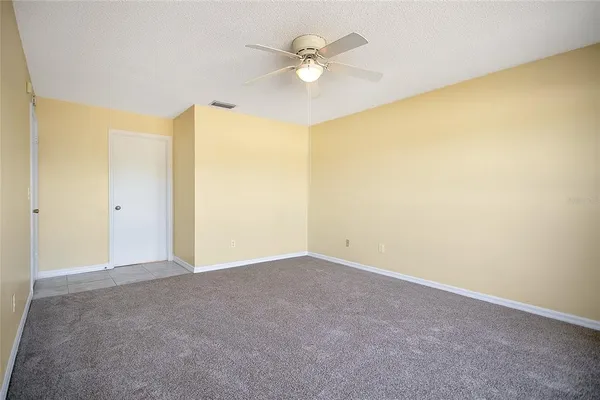 an empty room with a ceiling fan and a window
