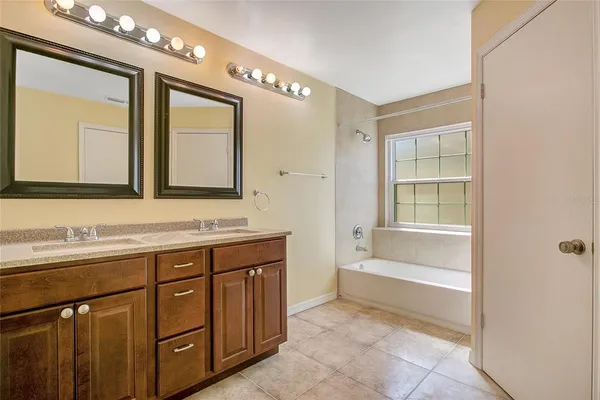 a spacious bathroom with a tub sink and mirror