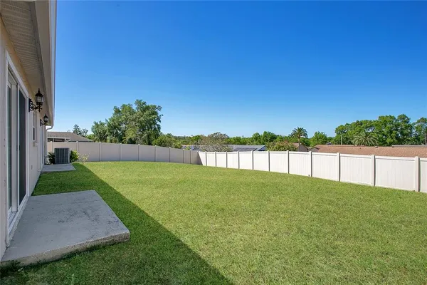a view of back yard with swimming pool and green space