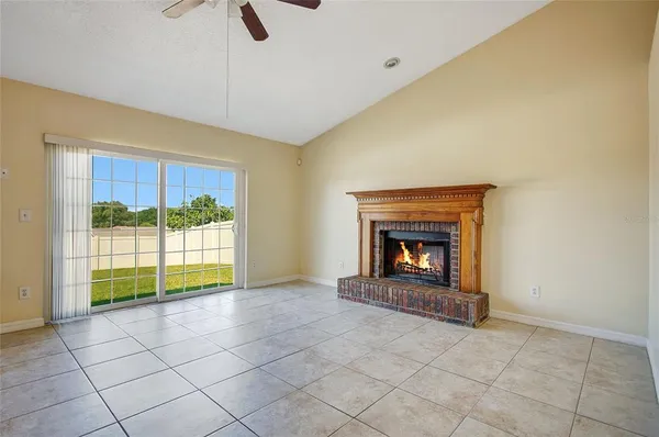 a view of an empty room with a fireplace and a window