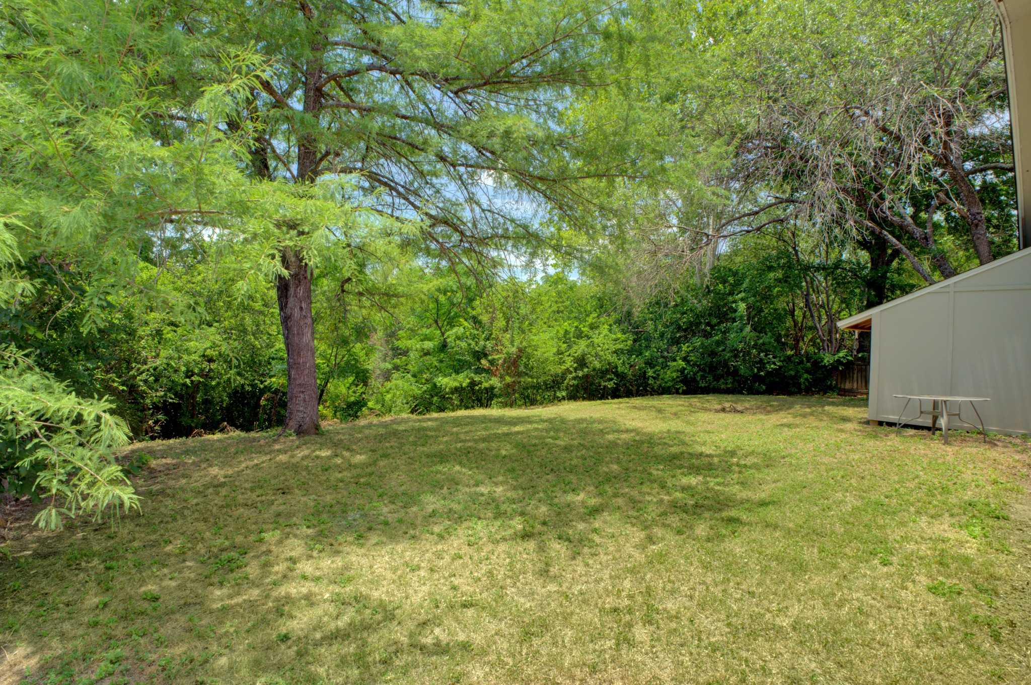 11811 Rotherham Drive Austin, TX 78754 - Photo 34 of 37 A verdant backyard offers a private outdoor oasis with ample space and mature trees.