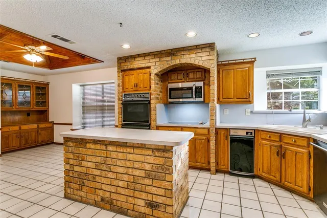 a kitchen with stainless steel appliances kitchen island granite countertop a stove a sink and a microwave