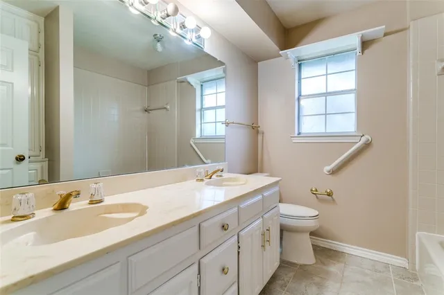 a bathroom with a granite countertop sink toilet and mirror